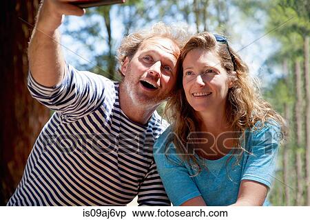 Couple taking selfie on smartphone in forest View Large Photo Image Stock Photography - Couple taking selfie on smartphone in forest. Fotosearch