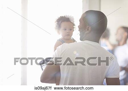 Stock Image - Father holding baby daughter. Fotosearch