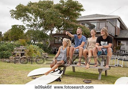 Four surfer friends sitting on picnic bench View Large Photo Image Stock Image - Four surfer friends sitting on picnic bench. Fotosearch