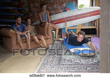Four young adult surfer friends messing around in surf shed View Large Photo Image Stock Photo - Four young adult surfer friends messing around in surf shed. Fotosearch