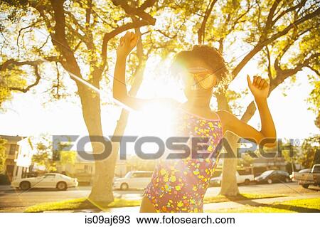 Stock Image - Girl in dancing in scuba goggles in garden. Fotosearch