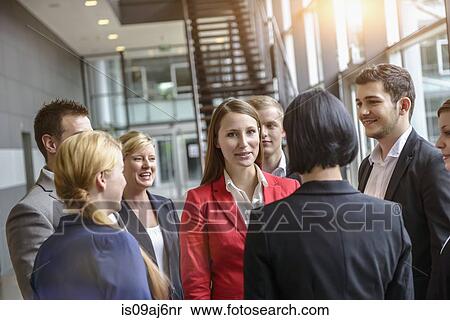 Stock Photography - Group of businesswomen and men having informal meeting. Fotosearch