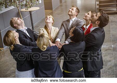 Group of businesswomen and men looking up with hands together in a circle View Large Photo Image Picture - Group of businesswomen and men looking up with hands together in a circle. Fotosearch