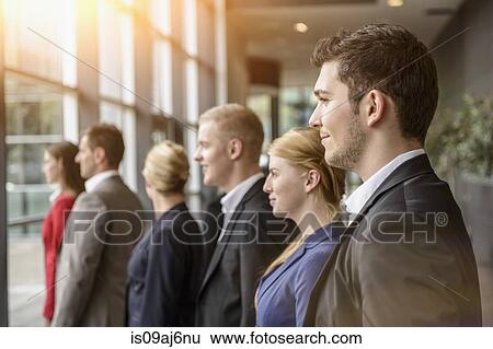 Group of smiling businesswomen and men standing in a row View Large Photo Image Stock Photograph - Group of smiling businesswomen and men standing in a row. Fotosearch