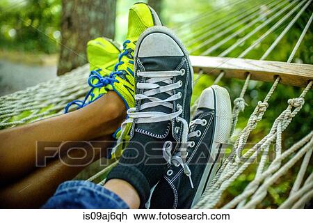 Stock Image - Legs of teenage boys lying in hammock. Fotosearch