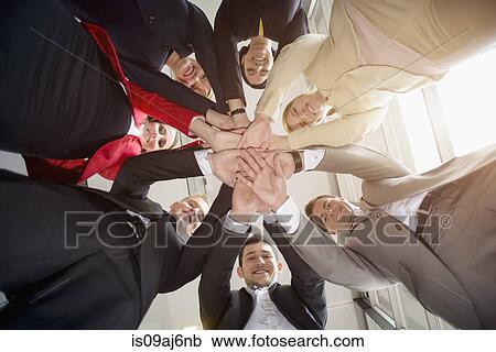 Low angle view of group of businesswomen and men in a circle with hands together View Large Photo Image Stock Image - Low angle view of group of businesswomen and men in a circle with hands together. Fotosearch