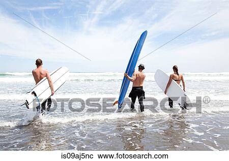 Male and female surfer friends standing in sea with surf boards View Large Photo Image Stock Image - Male and female surfer friends standing in sea with surf boards. Fotosearch