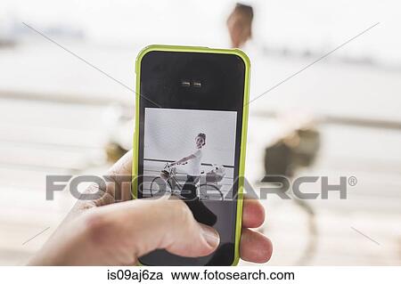 Male hand photographing girlfriend and bicycle with smartphone at riverside, New York City, USA View Large Photo Image Stock Image - Male hand photographing girlfriend and bicycle with smartphone at riverside, New York City, USA. Fotosearch