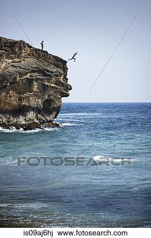Man jumping into sea from cliff, Poipu, Kaua'i, Hawaii, USA View Large Photo Image Stock Image - Man jumping into sea from cliff, Poipu, Kaua'i, Hawaii, USA. Fotosearch