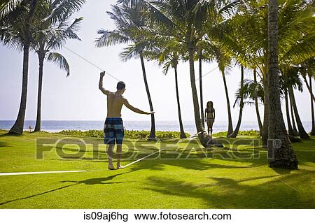 Man on slackline, Poipu, Kaua'i, Hawaii, USA View Large Photo Image Stock Image - Man on slackline, Poipu, Kaua'i, Hawaii, USA. Fotosearch