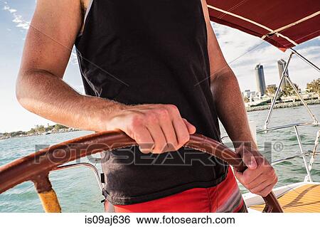 Man steering boat, close up View Large Photo Image Stock Photograph - Man steering boat, close up. Fotosearch