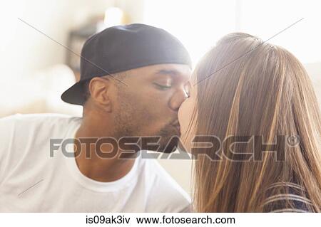 Stock Photo - Mid adult couple kissing. Fotosearch