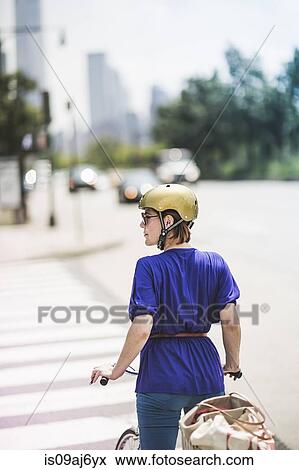 Mid adult woman cyclist waiting at pedestrian crossing, New York City, USA View Large Photo Image Stock Photo - Mid adult woman cyclist waiting at pedestrian crossing, New York City, USA. Fotosearch