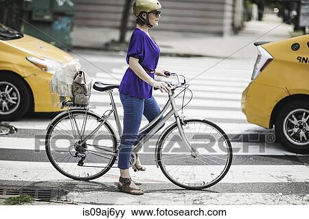 Mid adult woman cyclist waiting on pedestrian crossing, New York City, USA View Large Photo Image Stock Photo - Mid adult woman cyclist waiting on pedestrian crossing, New York City, USA. Fotosearch