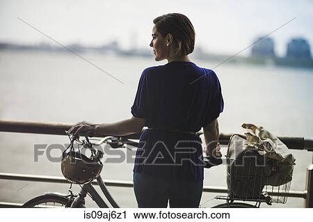 Mid adult woman cyclist with bicycle on riverside, New York City, USA View Large Photo Image Stock Image - Mid adult woman cyclist with bicycle on riverside, New York City, USA. Fotosearch