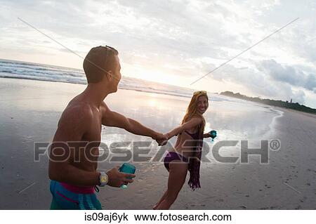 Mid adult woman leading boyfriend by hand on beach, Nosara, Guanacaste, Costa Rica View Large Photo Image Stock Image - Mid adult woman leading boyfriend by hand on beach, Nosara, Guanacaste, Costa Rica. Fotosearch