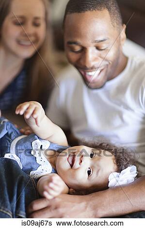 Mother and father playing with baby daughter View Large Photo Image Stock Photograph - Mother and father playing with baby daughter. Fotosearch