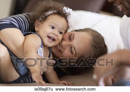 Mother and father playing with baby daughter View Large Photo Image Stock Photograph - Mother and father playing with baby daughter. Fotosearch