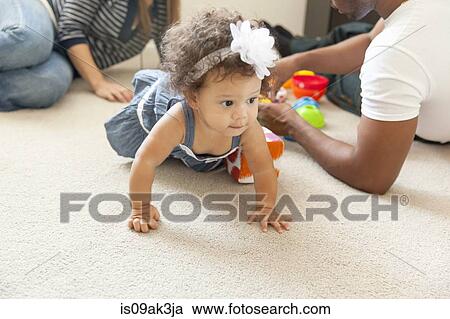 Stock Image - Mother and father playing with young daughter. Fotosearch