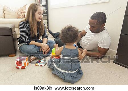 Stock Image - Mother and father playing with young daughter. Fotosearch