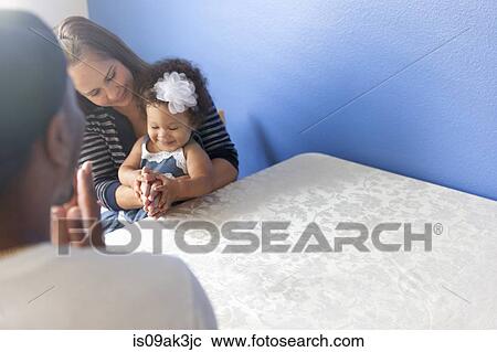 Stock Image - Mother and father playing with young daughter. Fotosearch