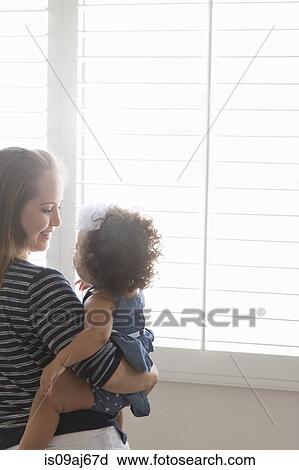 Stock Image - Mother holding baby daughter. Fotosearch