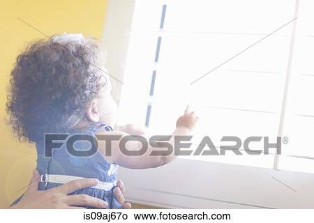 Mother holding baby daughter up to window View Large Photo Image Picture - Mother holding baby daughter up to window. Fotosearch