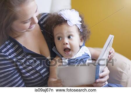Picture - Mother reading to baby daughter. Fotosearch