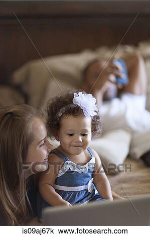 Mother showing baby daughter laptop screen View Large Photo Image Stock Image - Mother showing baby daughter laptop screen. Fotosearch