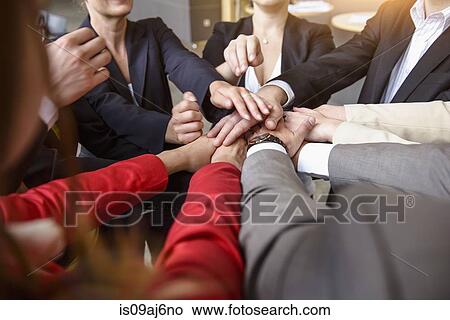 Over shoulder view of group of businesswomen and men with hands together in a circle View Large Photo Image Picture - Over shoulder view of group of businesswomen and men with hands together in a circle. Fotosearch