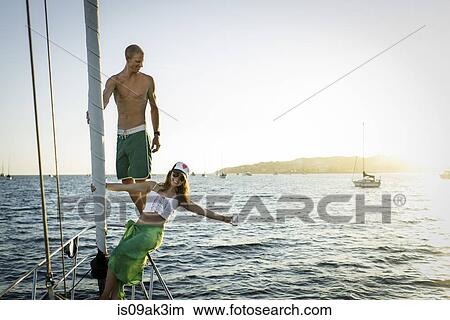 Picture - Playful mid adult couple on boat in ocean. Fotosearch