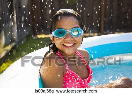 Portrait of girl in swimming goggles in garden paddling pool View Large Photo Image Stock Image - Portrait of girl in swimming goggles in garden paddling pool. Fotosearch