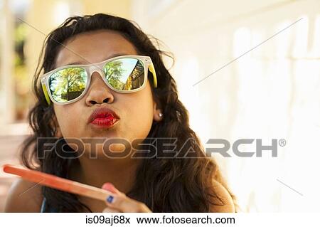 Portrait of girl with red lips and ice lolly stick pulling face View Large Photo Image Stock Photo - Portrait of girl with red lips and ice lolly stick pulling face. Fotosearch
