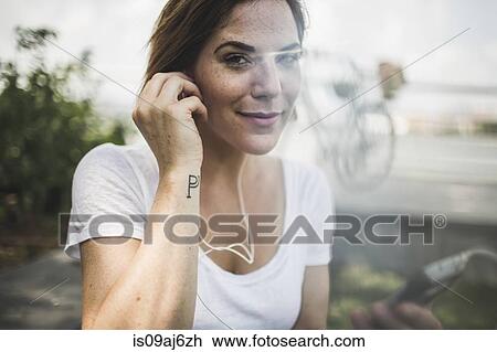 Portrait of mid adult woman listening to earphones View Large Photo Image Stock Image - Portrait of mid adult woman listening to earphones. Fotosearch