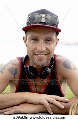 Portrait of smiling mid adult man wearing baseball cap at coast View Large Photo Image Stock Image - Portrait of smiling mid adult man wearing baseball cap at coast. Fotosearch