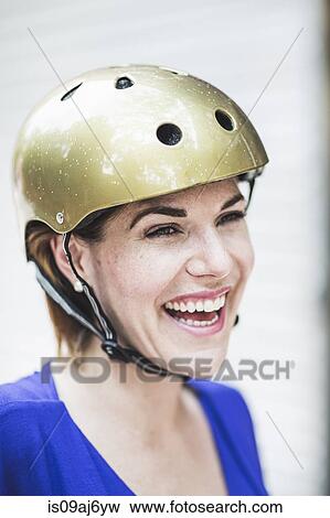 Stock Photo - Portrait of smiling mid adult woman cyclist wearing cycle helmet. Fotosearch