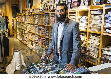 Portrait of tailor behind counter in men's clothes shop View Large Photo Image Picture - Portrait of tailor behind counter in men's clothes shop. Fotosearch