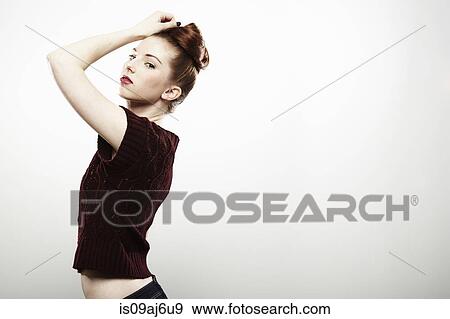 Stock Photo - Studio portrait of aloof young woman with hand on head. Fotosearch