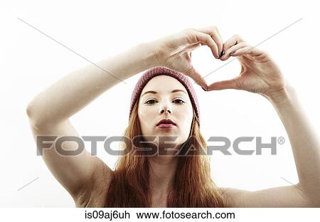 Studio portrait of young woman making heart shape with hands View Large Photo Image Stock Image - Studio portrait of young woman making heart shape with hands. Fotosearch