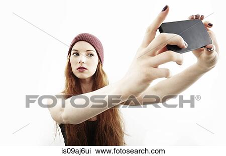 Studio portrait of young woman making selfie on smartphone View Large Photo Image Stock Image - Studio portrait of young woman making selfie on smartphone. Fotosearch