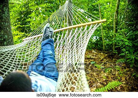 Stock Image - Teenage boy lying in hammock. Fotosearch
