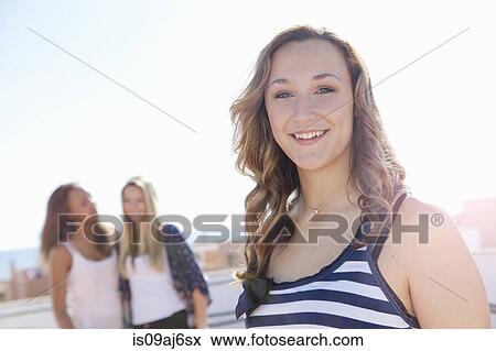 Teenage girl, friends in background View Large Photo Image Stock Photo - Teenage girl, friends in background. Fotosearch