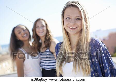 Stock Photo - Teenage girl, friends in background. Fotosearch