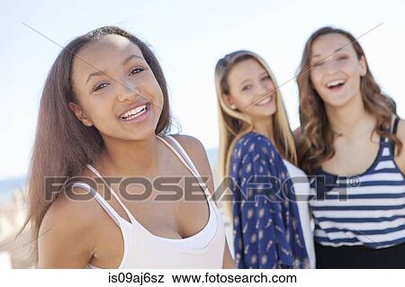 Stock Photo - Teenage girl, friends in background. Fotosearch