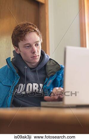 Teenager using laptop at table View Large Photo Image Stock Image - Teenager using laptop at table. Fotosearch