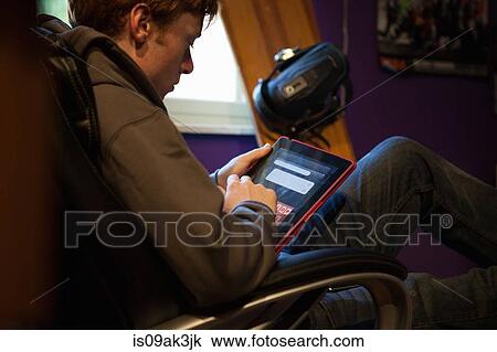 Teenager using tablet at home View Large Photo Image Stock Image - Teenager using tablet at home. Fotosearch