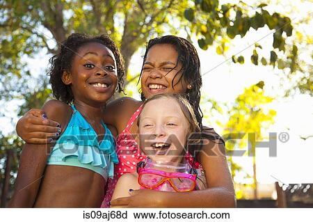 Stock Image - Three girls laughing in garden. Fotosearch