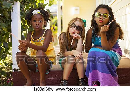 Three girls pulling faces on porch View Large Photo Image Stock Photo - Three girls pulling faces on porch. Fotosearch