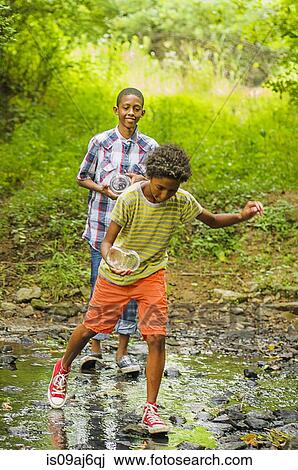 Two boys at edge of stream View Large Photo Image Stock Image - Two boys at edge of stream. Fotosearch