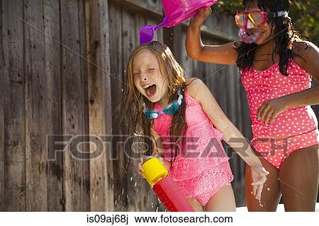 Two girls chasing each other with water in garden View Large Photo Image Stock Image - Two girls chasing each other with water in garden. Fotosearch